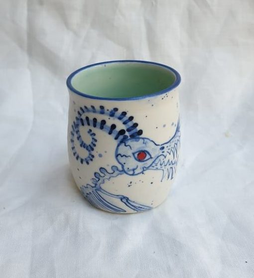 piccolo cup in white porcelain with celadon glazed interior. Creepy image