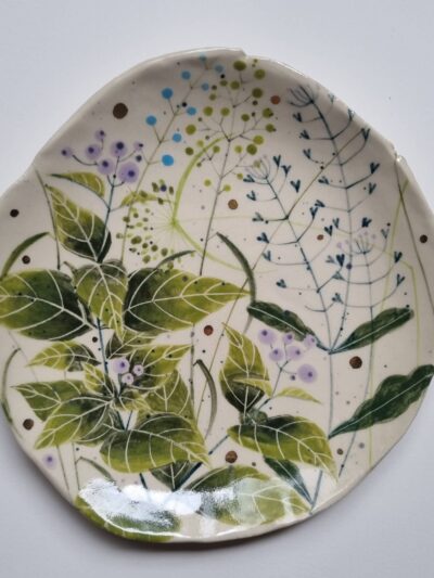Sarah's garden platter Coloured underglazes on midfire white clay. Slab form. white earthenware. Gold lustre. Clear glaze. Has attached hanging device