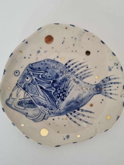 Fish platter. Cobalt oxide on midfire white clay. Slab form. Clear glaze. Has attached hanging device. Gold lustre