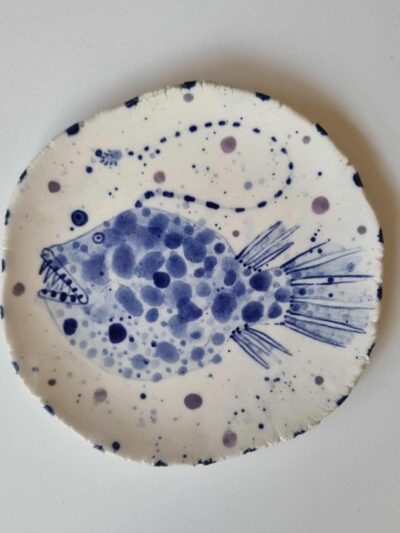 Fish platter. Cobalt oxide and coloured underglazes on midfire white clay. Slab form. Clear glaze. Has attached hanging device.