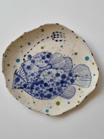 Fish platter. Cobalt oxide and coloured underglazes on midfire white clay. Slab form. Clear glaze. Has attached hanging device.